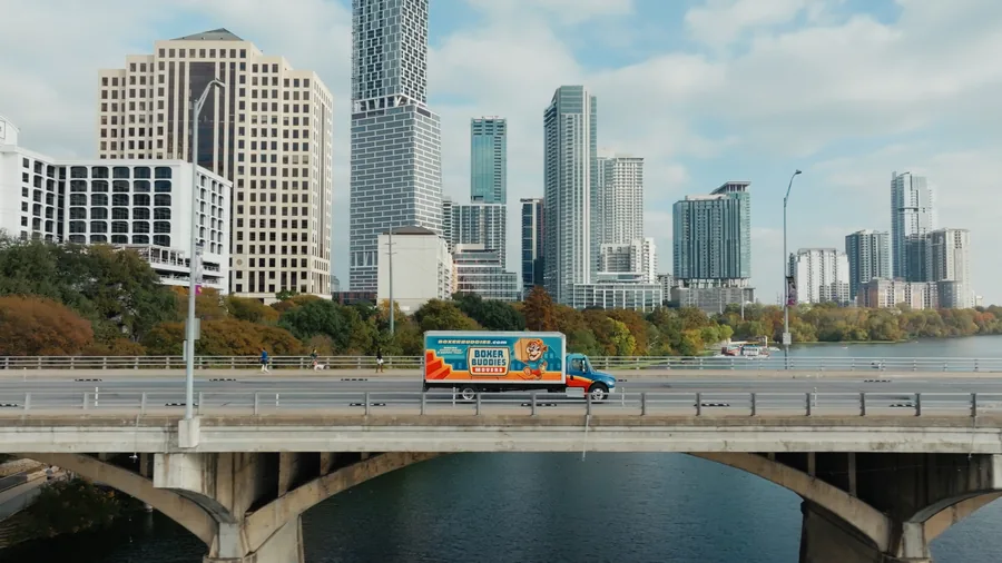 Boxer Buddies moving truck on Austin bridge — drone photography Austin TX